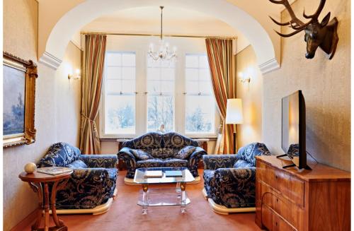 a living room with couches and a table at Bernsteinschloss in Wendorf