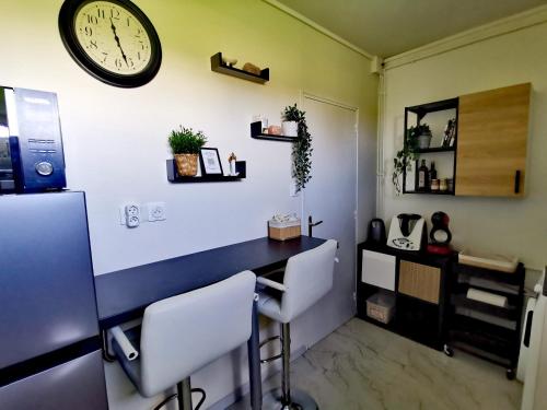 Habitación con escritorio y reloj en la pared en L'atelier de Jane en Sennecey-lès-Dijon