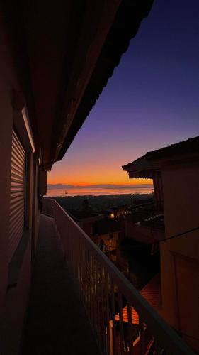 een uitzicht op de zonsondergang vanaf het balkon van een gebouw bij Endless view in Thessaloniki