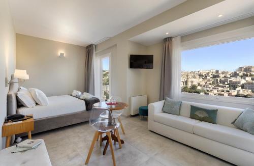 a living room with a bed and a couch and a window at Itria Modica in Modica