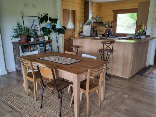 a wooden table and chairs in a kitchen at Cosy bright wooden house in Ariege mountains in Rimont