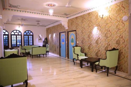 a room with chairs and a wall with wallpaper at Panna Vilas - A Lake Facing Boutique Hotel in Udaipur