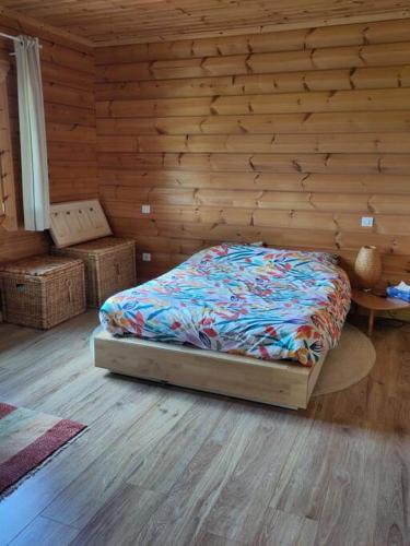 une chambre avec un lit et un mur en bois dans l'établissement Cosy bright wooden house in Ariege mountains, à Rimont
