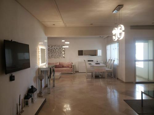 ein Wohnzimmer mit einem Sofa und einem Esszimmer in der Unterkunft Luxurious apartment in Fès