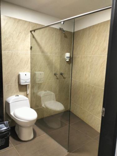 a bathroom with a toilet and a glass shower at Hotel El Cordobes in Marinilla