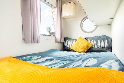 een bed in een kleine kamer met een raam bij Charming and cozy Houseboat near Giethoorn in Zwartsluis