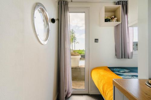 a bedroom with a door leading to a balcony at Charming and cozy Houseboat near Giethoorn in Zwartsluis