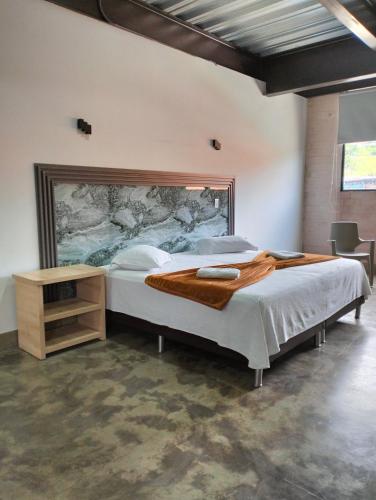 1 dormitorio con 1 cama grande y una gran pintura en la pared en Hotel El Cordobes, en Marinilla