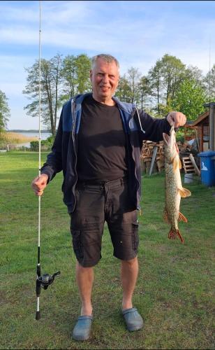 a man holding a fish on a fishing pole at Ferienhuette in Altfriesack