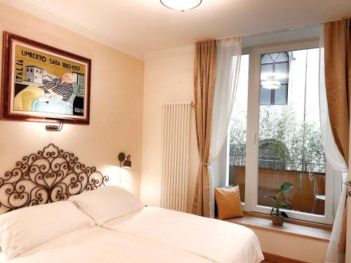 a bedroom with a bed and a large window at Casa Saba Trieste Luxury Apartment with terrace in Trieste
