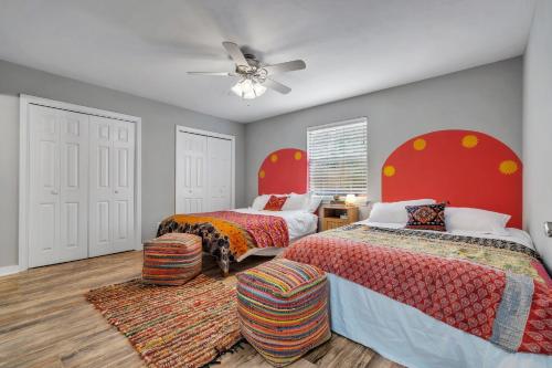 a bedroom with two beds and a ceiling fan at Boho Indian Oasis: 3bd - Pool - Tranquil Retreat in Tallahassee