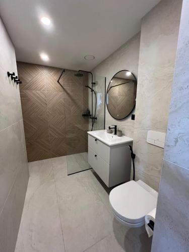 un bagno con un water, un lavandino e uno specchio di PÄRNU CENTER a Pärnu