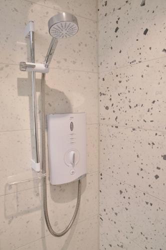 a shower in a bathroom with a shower head at The Sunset Nook in Ipswich