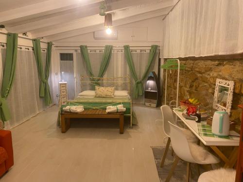 Cette chambre comprend un lit avec des rideaux verts et une table. dans l'établissement B&B Villa Irma guest house, à Crotone