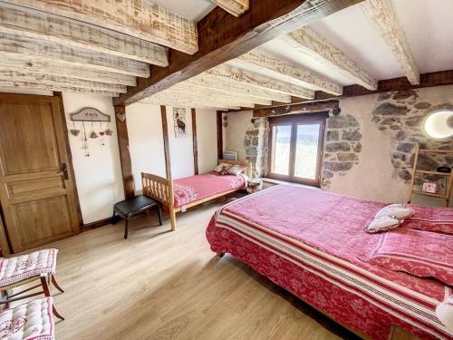 une chambre avec deux lits et un mur en pierre dans l'établissement La Grange d'Ardichen vue sur les montagnes, à Soulan