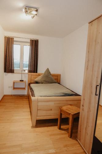 a bedroom with a wooden bed and a window at Ferienwohnung/Arbeiterwohnung Kampenwand in Rohrdorf