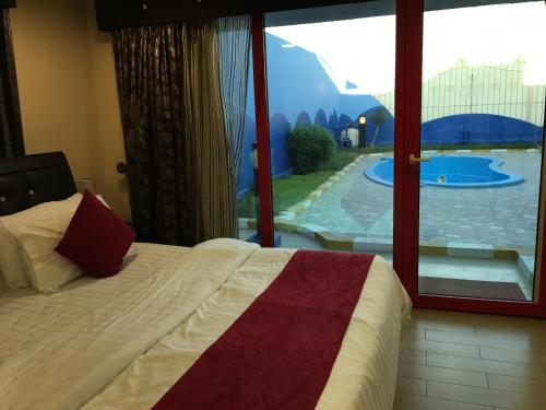 um quarto com uma cama e vista para uma piscina em منتجع درة الشرق للعائلات em Dammam