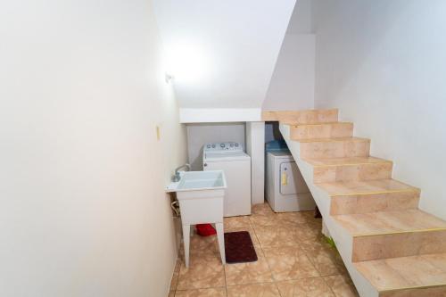 a small bathroom with a staircase and a sink at Villa Suites in Runaway Bay in Runaway Bay
