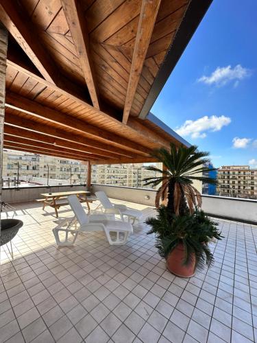 a patio with a table and chairs on a roof at myrooftop a 10 min dalla Reggia di Caserta in Caserta