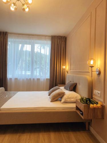 a bedroom with a large bed with a window at Zena Apartment in Ocna-Mureşului