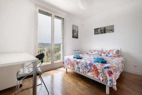 une chambre avec un lit, un bureau et une fenêtre dans l'établissement Les quatre vents, à Cagnes-sur-Mer