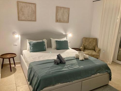 a bedroom with a large bed and a chair at Villa Pupetta Ostuni 4 bedrooms 4 bathrooms - swimming pool in Ostuni