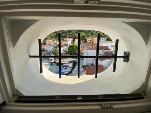a round window with a view of a city at Bed and Breakfast Palac in Valun