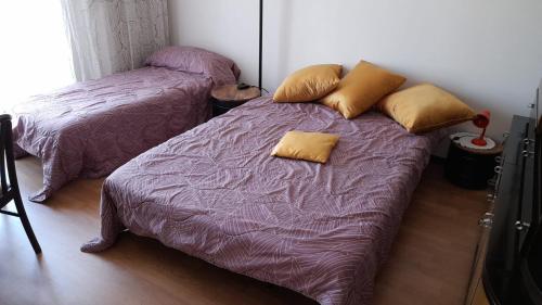 a bedroom with two beds with purple sheets and yellow pillows at Da Federico in Trieste
