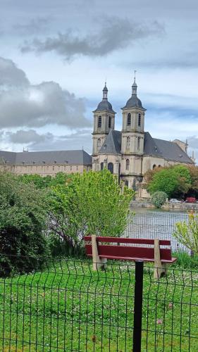 a bench in front of a building with a fence at Le gîte des Prémontrés in Pont-à-Mousson