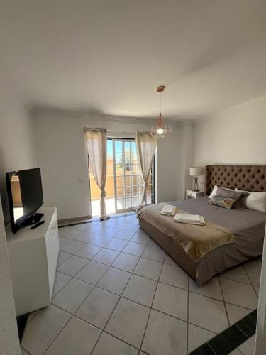 - une chambre avec un grand lit et une télévision dans l'établissement Moradia Almorávia, à Olhos de Água