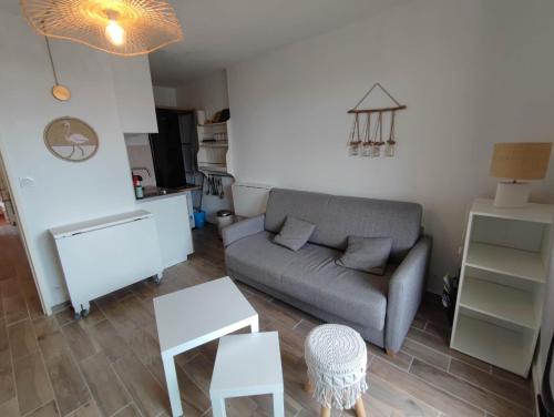ein Wohnzimmer mit Couch und Tisch in der Unterkunft Mimi&Cosy, appartement en bord de mer à Six-Fours-les-plages in Six-Fours-les-Plages