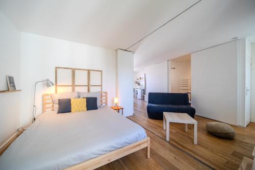 une chambre avec un grand lit et une chaise bleue dans l'établissement Atlantic Selection - Les toits de Beaurivage - La côte des Basques avec parking, à Biarritz