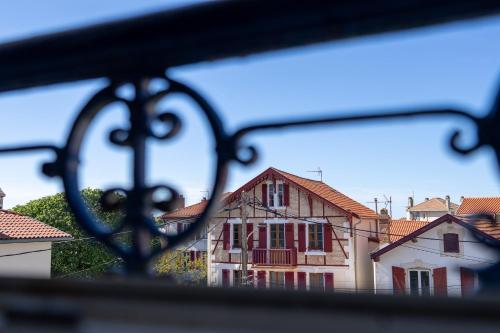une vue d'une maison depuis une clôture en fer dans l'établissement Atlantic Selection - Les toits de Beaurivage - La côte des Basques avec parking, à Biarritz