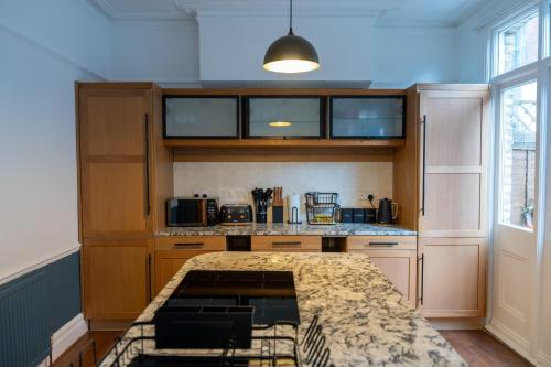a kitchen with wooden cabinets and a counter top at Chiswick 4 Bed Victorian Townhouse Minutes to Tube in London