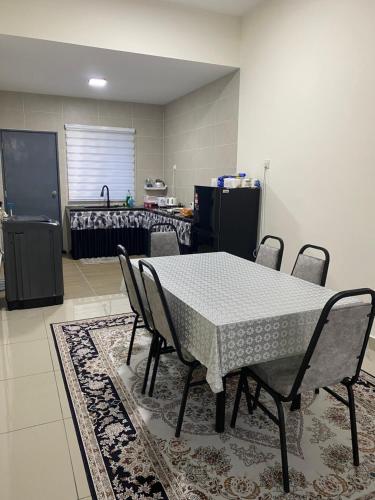 una mesa y sillas en una habitación con cocina en AFA Homestay, en Kuala Kubu Baharu