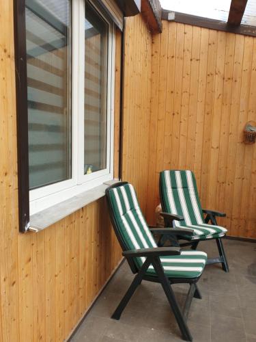 two chairs sitting on a porch next to a window at Einfache Monteurwohnung in Bleicherode in Bleicherode