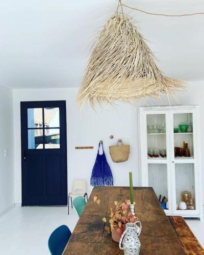 une salle à manger avec une table en bois et une porte bleue dans l'établissement Maison COSY proche centre et plages 7 couchages, à Vaux-sur-Mer