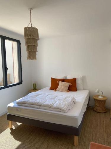 une chambre avec un lit avec des draps blancs et une fenêtre dans l'établissement Maison COSY proche centre et plages 7 couchages, à Vaux-sur-Mer