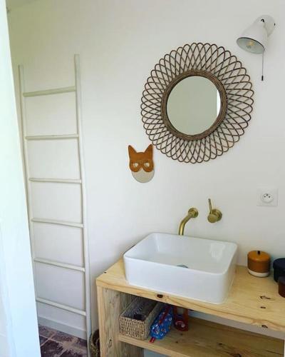 une salle de bain avec un lavabo et un miroir au mur dans l'établissement Maison COSY proche centre et plages 7 couchages, à Vaux-sur-Mer
