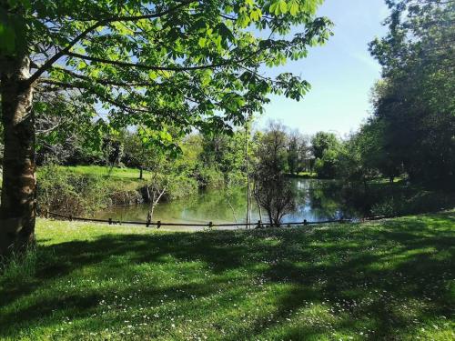 a body of water with a fence next to a park at Maison COSY proche centre et plages 7 couchages in Vaux-sur-Mer