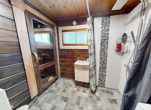 La salle de bains est pourvue d'un lavabo et d'une douche. dans l'établissement Levin Rankis, à Kittilä