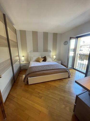 a bedroom with a large bed with striped walls at SWEETHOME ARENA VIEW - con parcheggio in Verona