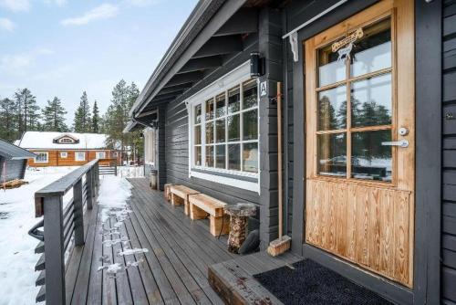 a building with a wooden door and a bench on a porch at Levin Rankis in Kittilä