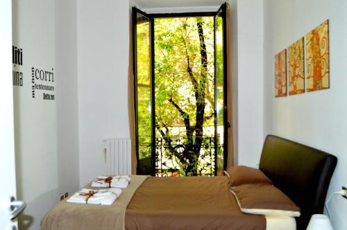 ミラノにあるLa Casa Dei Viaggiatoriのベッドルーム1室(ベッド1台付)、木の窓