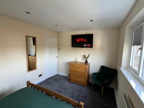 a bedroom with a bed and a tv on the wall at Wilford Charm Spacious 3BR Retreat in Nottingham in Nottingham