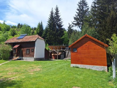 a house and a barn in a yard at Cabana Miska Chalet in Miercurea-Ciuc