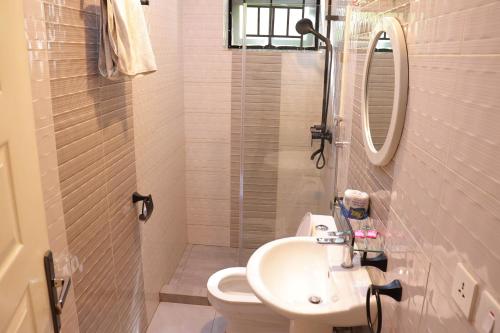 a bathroom with a sink and a toilet and a shower at Kigali Fantastic Apartment in Kigali