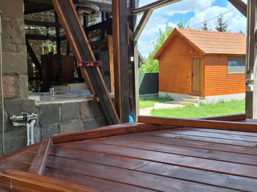 an open door to a wooden deck with a dog house at Cabana Miska Chalet in Miercurea-Ciuc