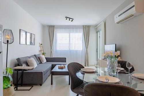 a living room with a couch and a table at Stylish One-Bedroom Sea Retreat in Paralimni