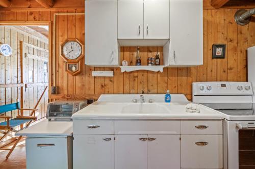a kitchen with a sink and a clock on the wall at Omena Point Paradise Waterfront Sunrise in Suttons Bay